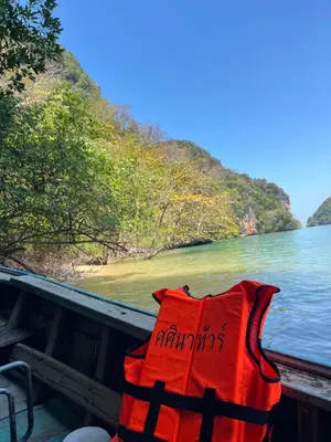 a red bag sitting on a boat in the water at Ban Tha Ton Do Koh Yao noi in Ko Yao Noi