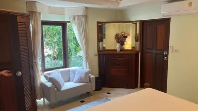 a living room with a chair and a mirror at Bali style 4 bedroom beachfront Villa Ao Yon in Ban Ao Makham
