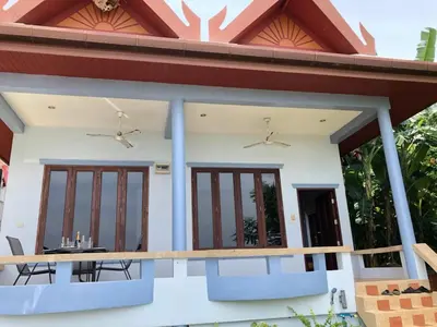 a house with a balcony with a table at Bali style 4 bedroom beachfront Villa Ao Yon in Ban Ao Makham