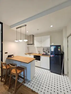 a kitchen with white cabinets and a black refrigerator at The Title Halo 1 Jupiter in Nai Yang Beach