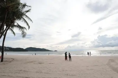 a group of people standing on a beach at OYO 292 The Oddy Hip Hotel in Patong Beach