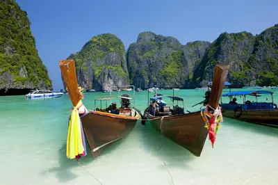 two boats in the water in front of a beach at OYO 681 Paradise Hotel in Ao Nang Beach