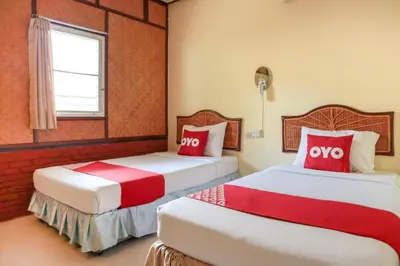 two beds in a room with red and white at OYO 681 Paradise Hotel in Ao Nang Beach
