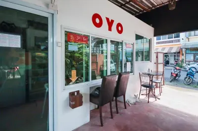 a store front with chairs and a table on a street at OYO 1163 Eden Hostel in Phuket Town
