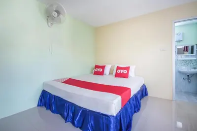 a bedroom with a bed with two red pillows at OYO 1163 Eden Hostel in Phuket Town