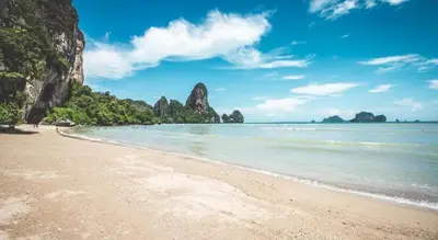 a beach with some rocks in the water at Chaya Resort in Ao Nang Beach