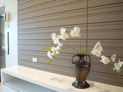 a vase with white flowers sitting on a shelf at Elegancy Sansabai Hotel in Patong Beach