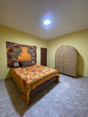 a bedroom with a bed with a painting on the wall at Lakshmi beach house in Phuket Town