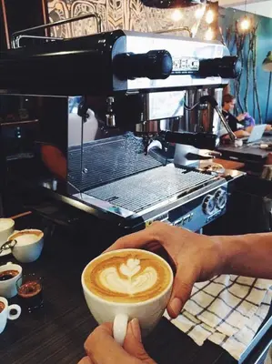 a person is holding a cup of coffee at Mini Boxtel Aonang Hostel in Ao Nang Beach