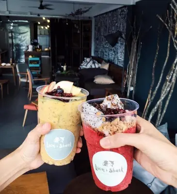 two hands holding up two cups of drinks at Mini Boxtel Aonang Hostel in Ao Nang Beach