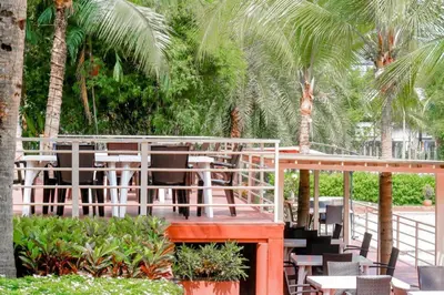 a patio with chairs and tables and palm trees at Royal Lee Resort and Spa in Ban Bo Han
