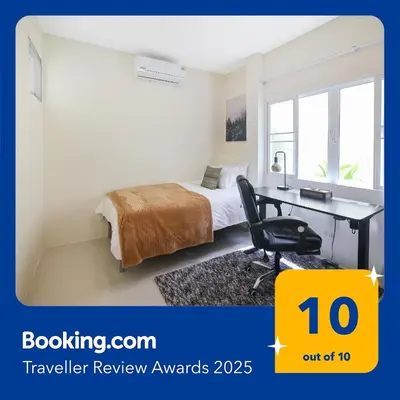a bedroom with a bed and a desk with a computer at Spacious Family Garden Villa - Huge Pool & Gym Access in Thalang