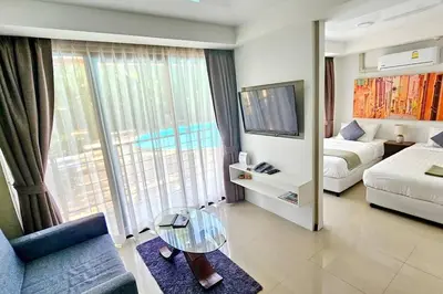 a living room with a bed and a couch and a television at Новая квартира с выходом к бассейну in Mai Khao Beach
