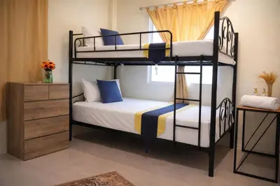 two bunk beds in a room with a window at Grand Chalong Family House in Chalong