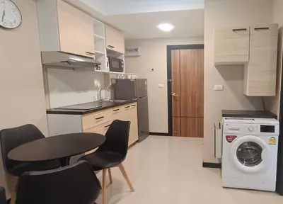 a kitchen with a table and chairs and a washing machine at Rawai Beach Condo by Holy Cow in Nai Harn Beach
