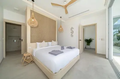 a bedroom with a large white bed and pendant lights at Tropical Brand New 4BR Pool Villa Mina, just 5 min Drive from Naiharn in Rawai Beach