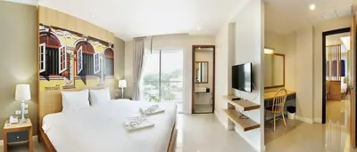 a hotel room with a bed and a television at Ratana Hotel Rassada, PHUKET TOWN- SHA Extra Plus in Phuket Town