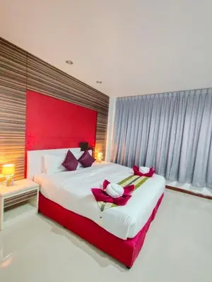 a bedroom with a large bed with a red headboard at Patong Max Value Hotel in Patong Beach