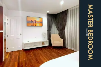 a living room with a chair and a painting on the wall at Luxury Apartment at a Bargain in Kamala Beach