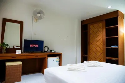 a bedroom with a bed and a desk with a television at Diamond Place Ao Nang in Ao Nang Beach