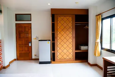 a kitchen with a refrigerator and a wooden door at Diamond Place Ao Nang in Ao Nang Beach