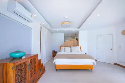 a bedroom with a bed and a blue vase on a dresser at Coco Golf Villa in Ban Huai Luk (1)