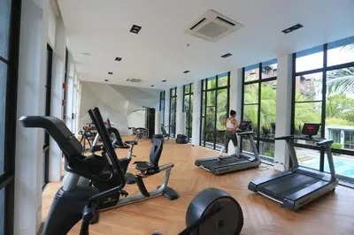 a gym with treadmills and ellipticals in a building at Saturdays by Holy Cow, pool view in Rawai Beach