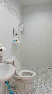 a white bathroom with a toilet and a sink at B&N House in Nai Yang Beach