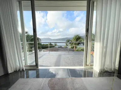 an open sliding glass door with a view of the ocean at Vipa Seaview Villa in Patong Beach