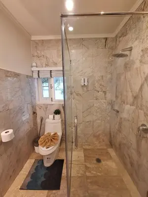 a bathroom with a toilet and a glass shower at Vipa Seaview Villa in Patong Beach