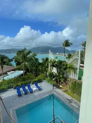 a swimming pool with chairs and a view of the water at Vipa Seaview Villa in Patong Beach