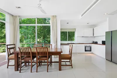 a kitchen and dining room with a wooden table and chairs at Kamala Hills Naka - Villa 15 in Kamala Beach