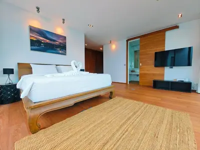 a bedroom with a large bed and a flat screen tv at \u62c9\u5a01Eva11\u4e09\u5367\u6c99\u6ee9\u522b\u5885 \u51fa\u95e8\u5c31\u662f\u5927\u6d77 \u4e09\u4e2a\u5367\u5ba4\u90fd\u662f\u6d77\u666f\u72ec\u536b in Phuket Town
