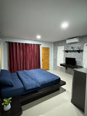 a bedroom with a blue bed and a red curtain at Mimi Home in Ko Yao Noi