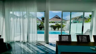 a dining room with a view of a swimming pool at Kamala Garden View Villas by Aladdin in Kathu
