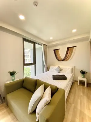 a bedroom with a bed and a couch and a window at Cozy 1BR in Laguna Skypark Celeste Bangtao, Iinfinity Pool in Bang Tao Beach