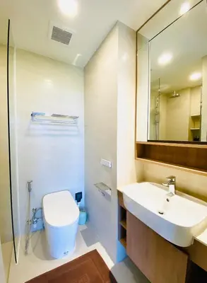 a bathroom with a sink and a toilet and a mirror at Cozy 1BR in Laguna Skypark Celeste Bangtao, Iinfinity Pool in Bang Tao Beach