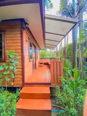 a house with a wooden porch with a deck at Samran Resort in Chalong