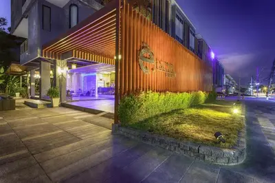 a building with a wall with grass on the side of it at Escape Villa in Ban Bang Khu