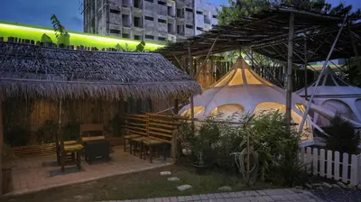 a patio with a table and chairs and tents at Bambus Restaurant, Bar & Glamping in Patong Beach