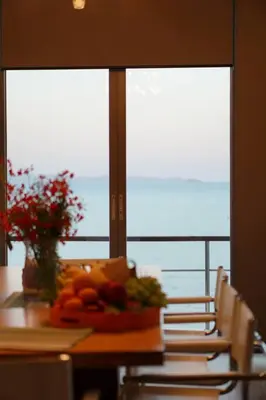 a table with a bowl of fruit on a table with chairs at 4bedroom Villa Siray Beach Front in Phuket Town