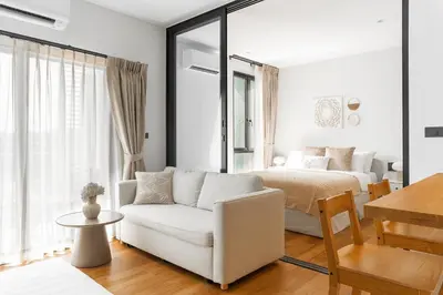 a white living room with a bed and a white couch at Title Halo Tenderness Naiyang Pool View Gym in Nai Yang Beach
