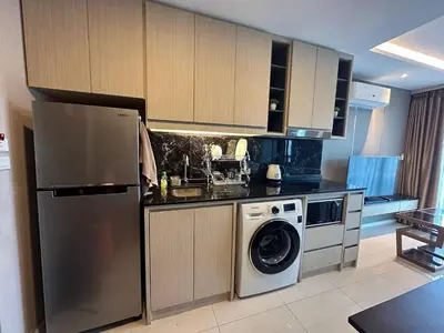 a kitchen with a refrigerator and a washing machine at Mida Grande Resort Surin by Mill in Surin Beach