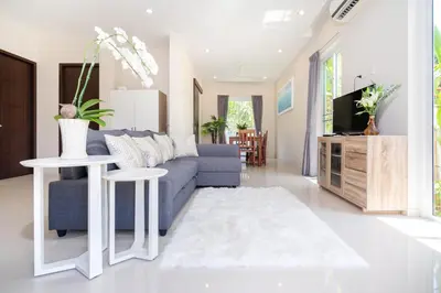 a living room with a blue couch and a tv at 1 Bedroom Villa in Rawai - v19 t in Ban Saiyuan (1)