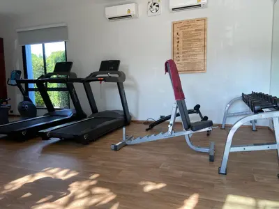 a gym with two treadmills and two exercise bikes at Title V Summer Dream Pool View Gym Hammam in Rawai Beach
