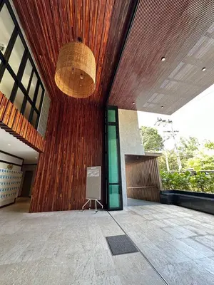 a building with a wooden wall with a sign on it at Title V Summer Dream Pool View Gym Hammam in Rawai Beach