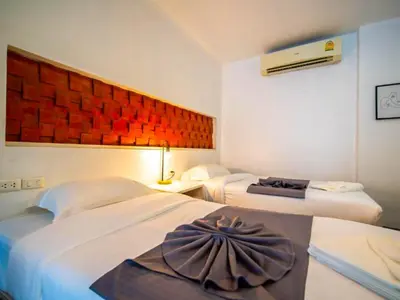 a hotel room with two beds and a fan at The Thai Guesthouse and Hostel in Patong Beach