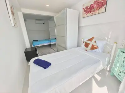 a small white room with a bed and a mirror at Villa 3 Chambres avec piscine, Rawai, Phuket in Ban Saiyuan (1)
