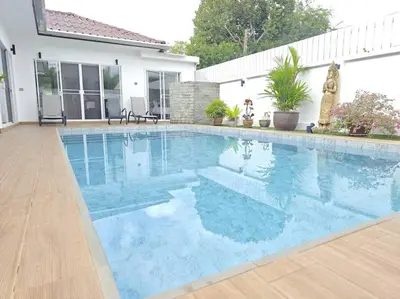 a swimming pool with blue water in front of a house at Villa 3 Chambres avec piscine, Rawai, Phuket in Ban Saiyuan (1)