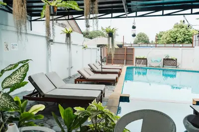 an outdoor pool with chaise lounge chairs and a swimming pool at Saiyuan Residence Phuket in Rawai Beach